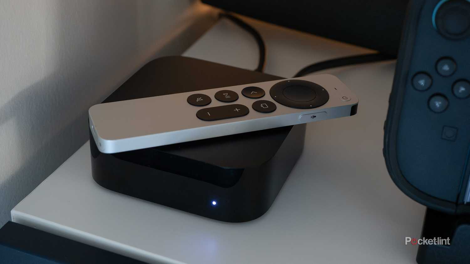Apple TV 4K در قفسه تلویزیونی نشسته است