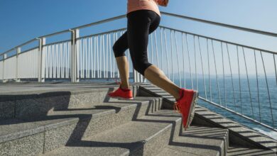 A person runs up stairs near the ocean.