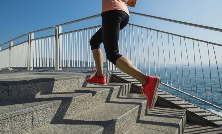 A person runs up stairs near the ocean.