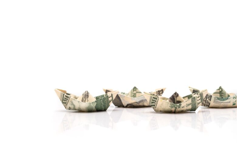row of paper ships from dollar banknotes