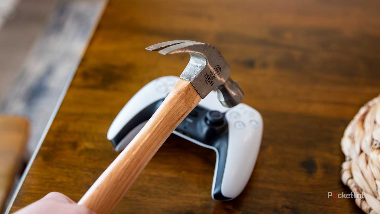 عکس ثابتی از یک چکش که روی کنترلر پلی استیشن 5 معلق است. 