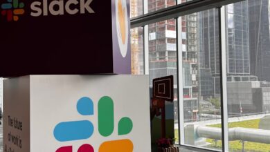 Cubes with Slack name and logo stacked on one another with city view in background.