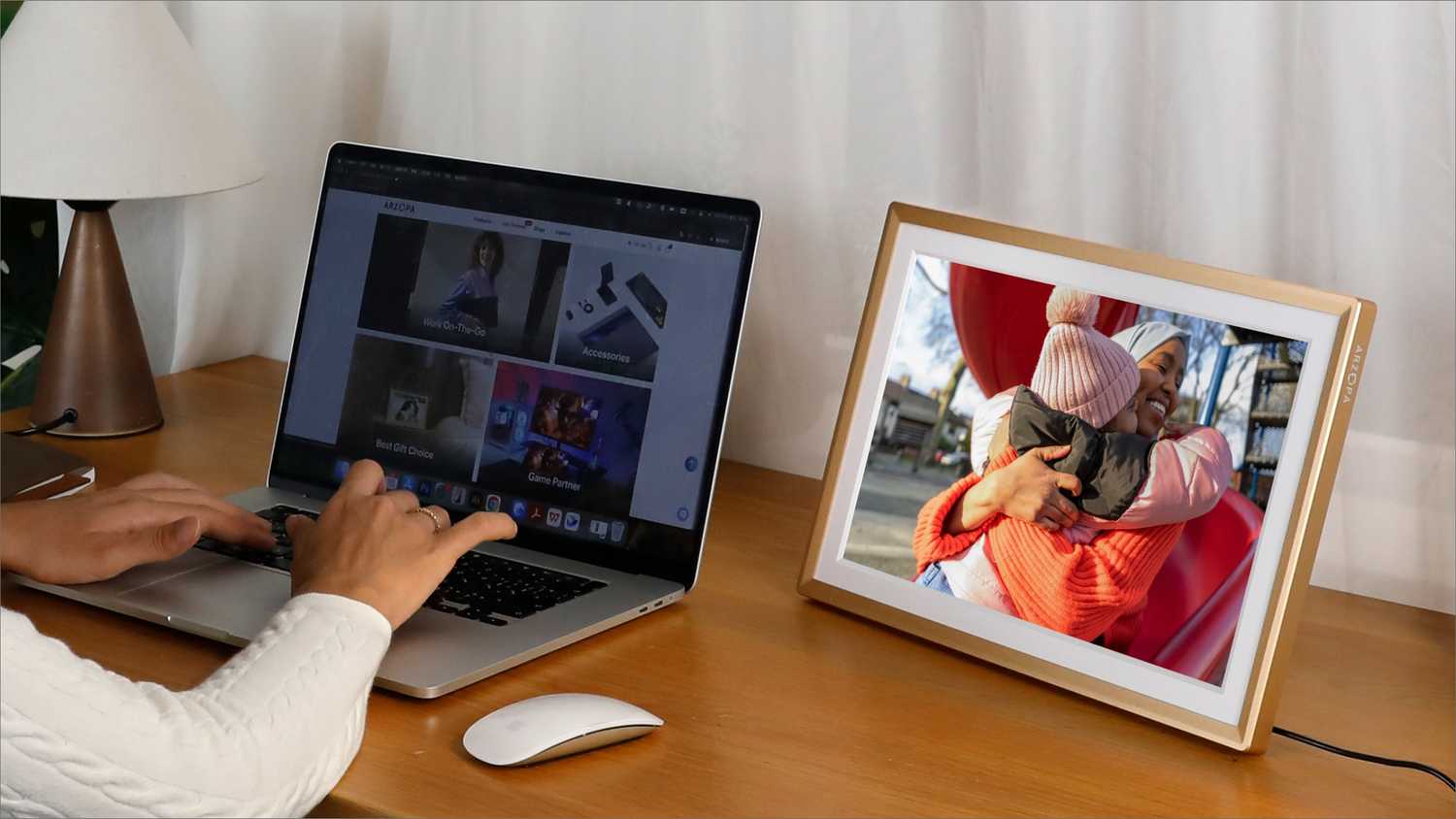 با دست روی لپ تاپ در کنار قاب عکس دیجیتال تایپ کنید