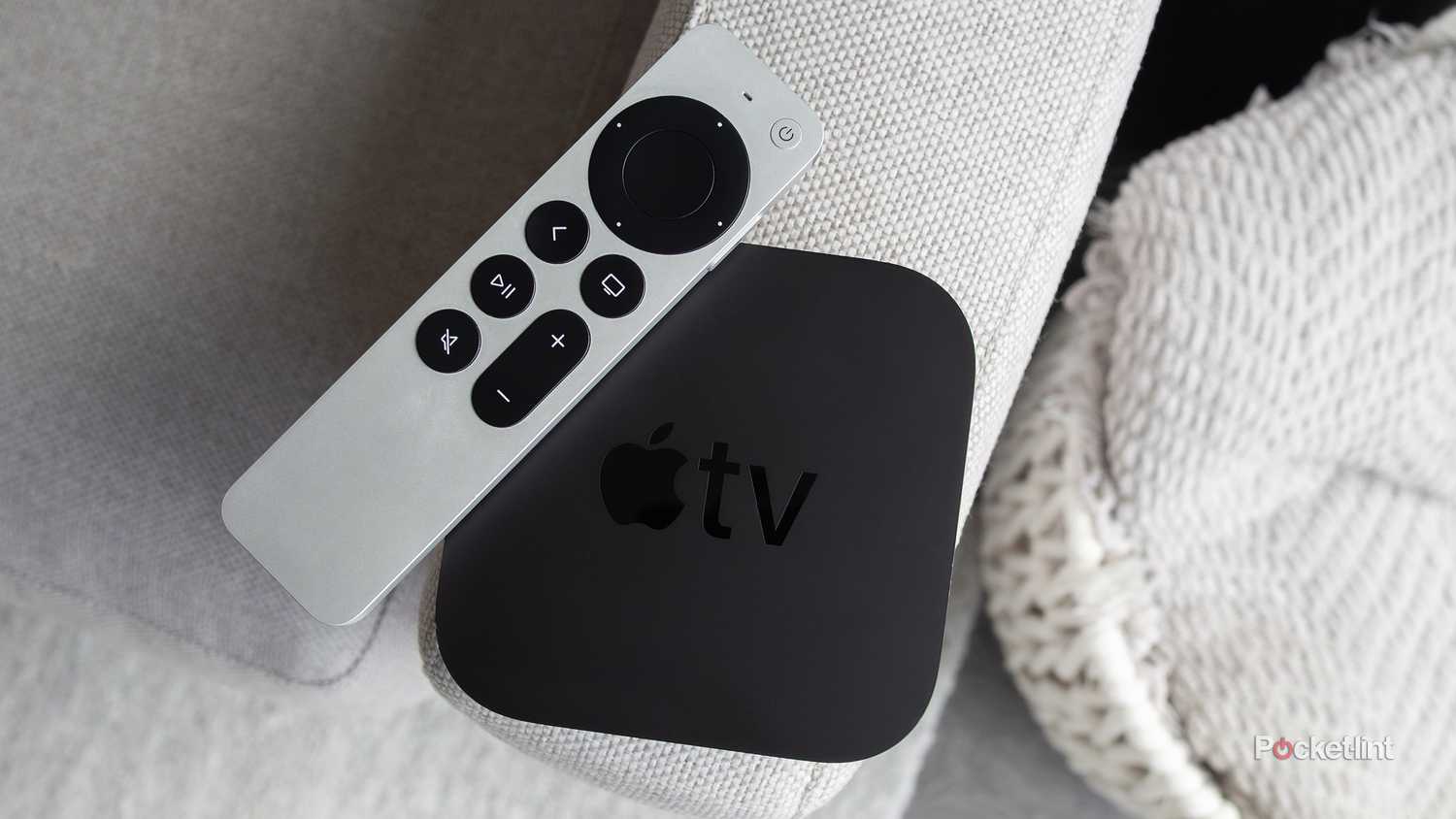 Apple TV 4K و Siri Remote که روی یک مبل نشسته است