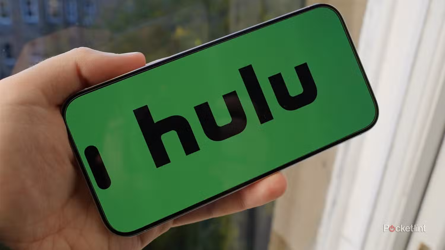 لوگوی Hulu روی گوشی در حال نگه‌داشتن منظره