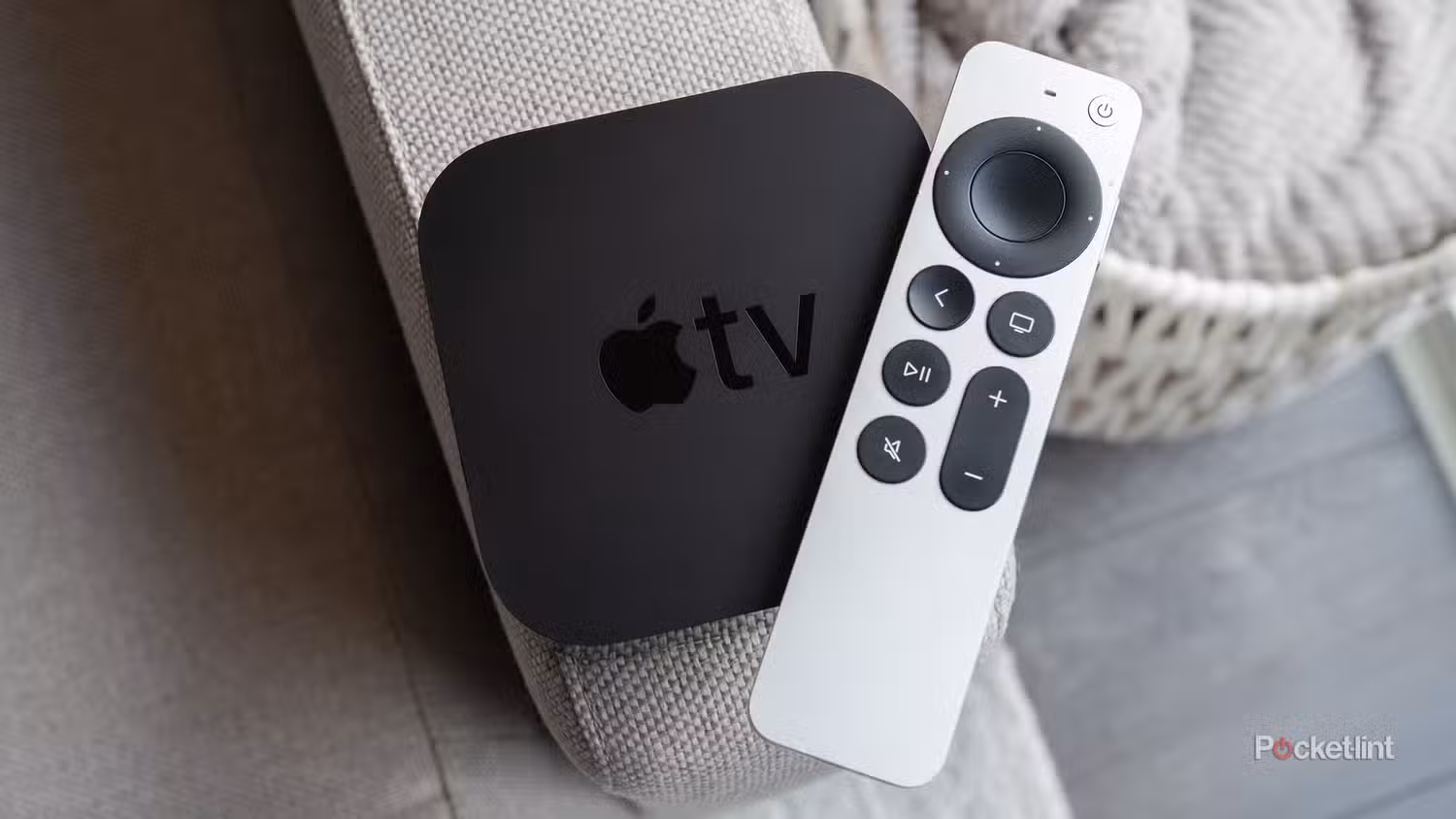 یک Apple TV 4K (2021) و Siri Remote که روی یک مبل نشسته است.