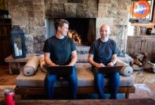 Thatch founders sitting on couch in front of fireplace