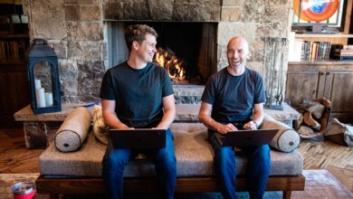 Thatch founders sitting on couch in front of fireplace