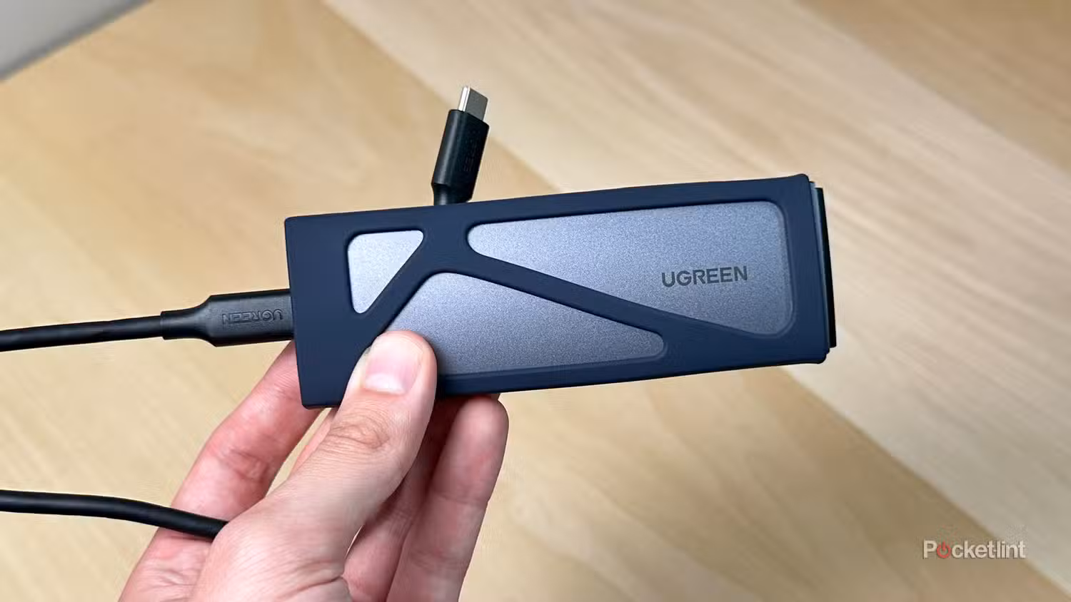 یک محفظه SSD UGREEN در دست.